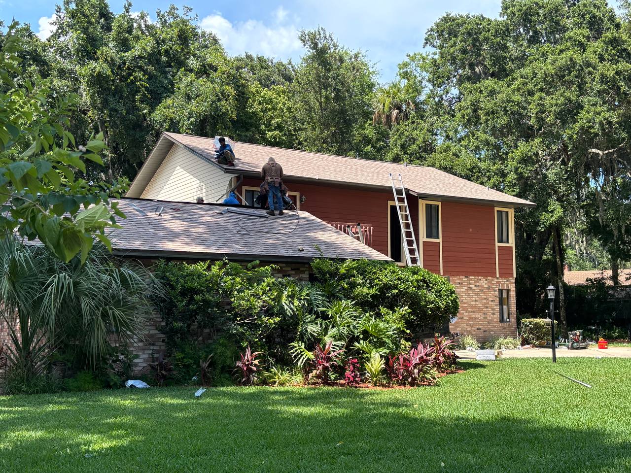 Affordable Roofing crew installing new shingles on two-story home in Volusia County Florida